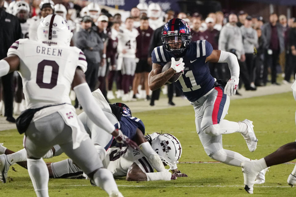 Mississippi wide receiver Jordan Watkins (11) runs as Mississippi State safety Jalen Green (0) defends during the first half of an NCAA college football game in Oxford, Miss., Thursday, Nov. 24, 2022. (AP Photo/Rogelio V. Solis)