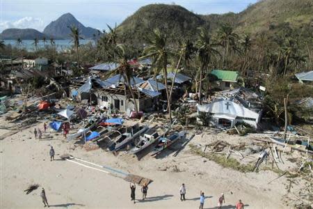 An aerial view shows damaged houses, as residents wave for help after Typhoon Haiyan hit a village in Panay island, in northern Iloilo Province, central Philippines November 9, 2013. REUTERS/Leo Solinap