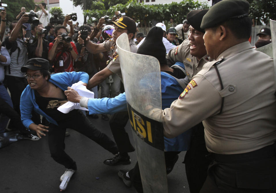 Indonesian police officers try to catch students during a protest against price hikes on fuel, in Jakarta, Indonesia, Wednesday, March 14, 2012 .(AP Photo/Achmad Ibrahim)