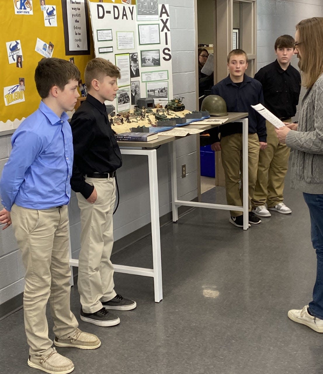 Windham Junior High School seventh graders, from left, Alex Eye, Bryan Smithberger, Michael Bolyard and Devin Sherman present a project about D-Day to Youngstown State University graduate students.