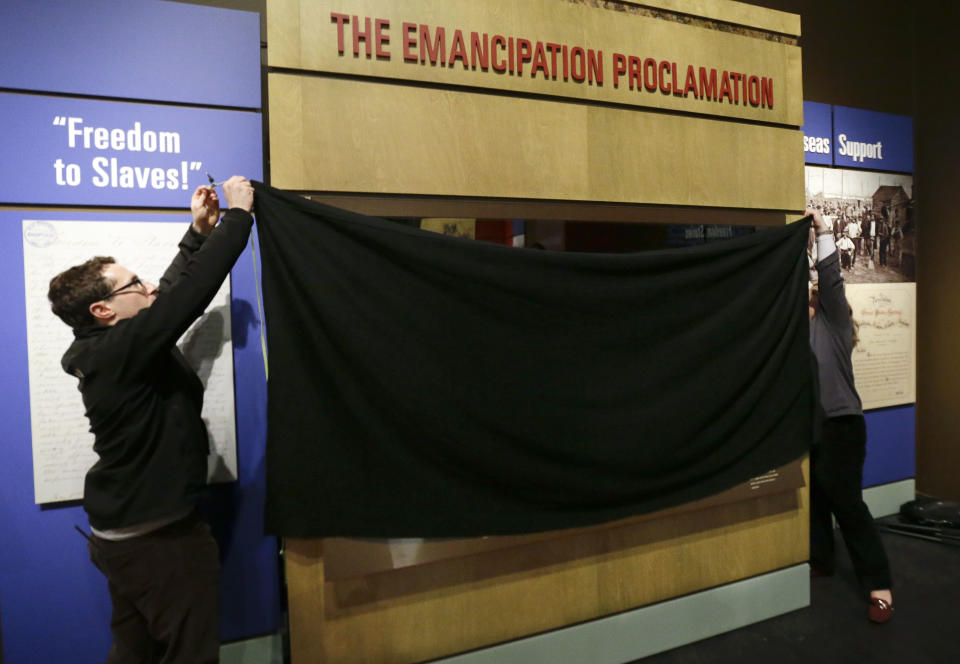 Daniel Falk, left, and Karen Hibbitt, right, both of the National Archives in Washington, D.C., cover the the Emancipation Proclamation following a special viewing at the Tennessee State Museum on Monday, Feb. 11, 2013, in Nashville, Tenn. The document is at the museum in conjunction with an exhibit titled Discovering the Civil War from the National Archives. The papers will only be on view for a total of 72 hours from Tuesday, Feb. 12, and close Monday, Feb. 18, and must be covered and protected from light when not being viewed. (AP Photo/Mark Humphrey)