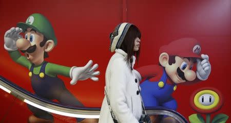 A shopper rides an escalator past Nintendo advertisements at an electronics retail store in Tokyo January 20, 2014. REUTERS/Yuya Shino