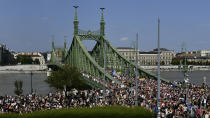 People march across the Szabadsag, or Freedom Bridge over the River Danube in downtown Budapest during a gay pride parade in Budapest, Hungary, Saturday, July 24, 2021. Rising anger over policies of Hungary's right-wing government filled the streets of the country's capital on Saturday as thousands of LGBT activists and supporters marched in the city's Pride parade. (AP Photo/Anna Szilagyi)