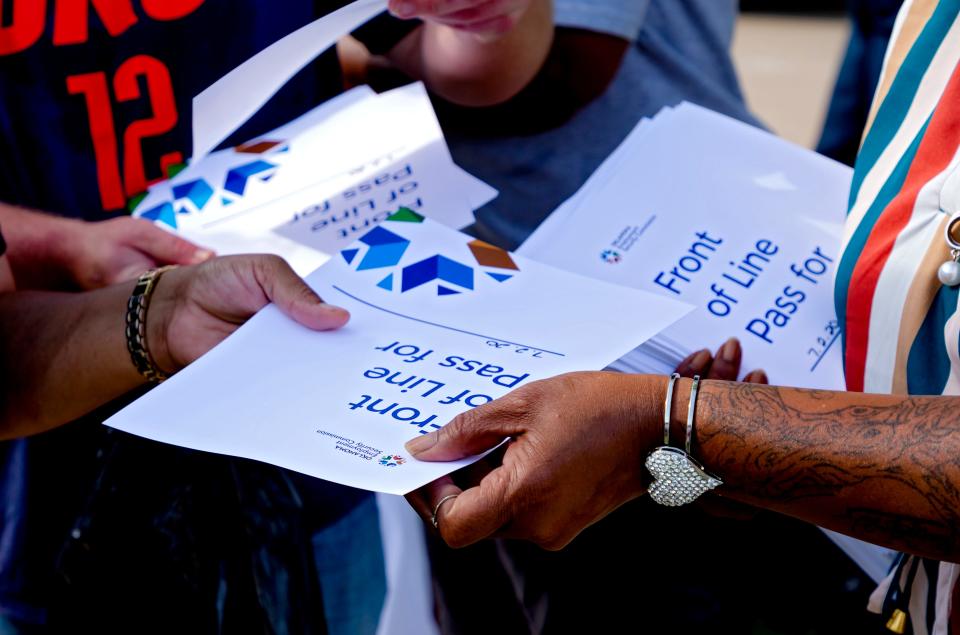 People receive their first in line slips to return on July 1 as hundreds of people wait in line during the first day of the Oklahoma Employment Security Commission unemployment filing event.