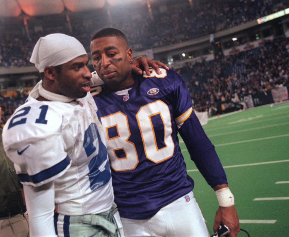 Sanders of the Dallas Cowboys (left) and Minnesota Vikings wide receiver Cris Carter greet each other following a Vikings playoff victory in 1999. (Photo: JUDY GRIESEDIECK/Star Tribune via Getty Images)