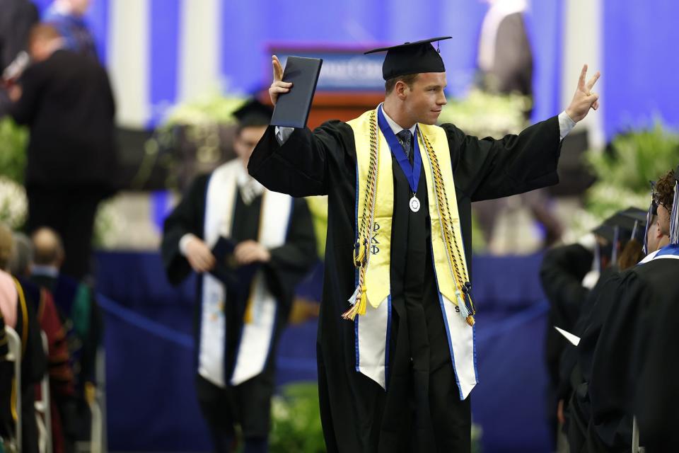 A graduate receives his diploma Saturday at Hilldale College's commencement ceremony.