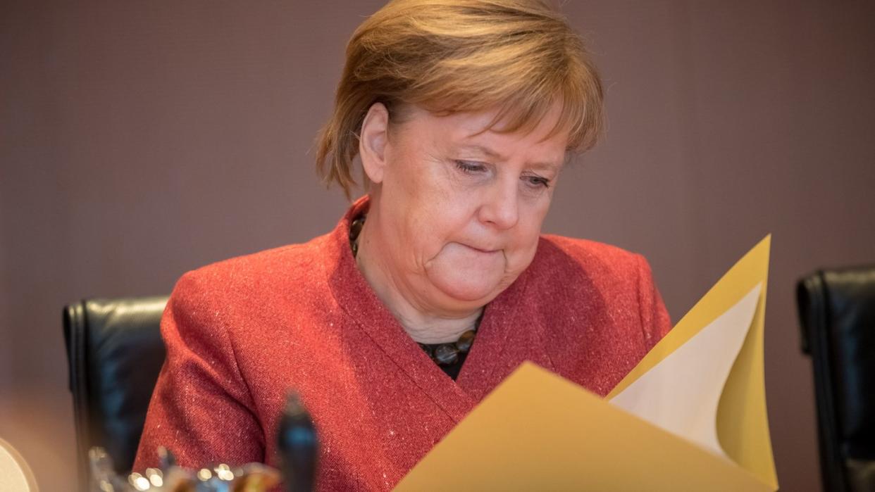 Kanzlerin Angela Merkel schaut vor Beginn der Sitzung des Bundeskabinetts in ihre Akten. Foto: Michael Kappeler