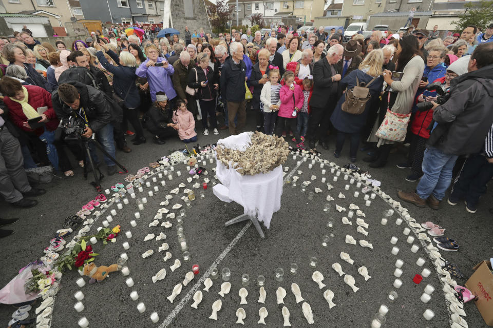 FILE - In this Aug. 26, 2018 file photo, People gather to protest at the site of the former Tuam home for unmarried mothers in County Galway, Ireland. The Vatican has indicated its support for a campaign to exhume the bodies of hundreds of babies who were buried on the grounds of a Catholic-run Irish home for unwed mothers to give them a proper Christian burial. The Vatican’s ambassador to Ireland, Archbishop Jude Thaddeus Okolo, said in a July 15, 2020 letter to the amateur Irish historian behind the campaign that he shared the views of the archbishop of Tuam, Ireland, Michael Neary, who has said it was a “priority” for him to re-inter the bodies in consecrated ground. (Niall Carson/PA via AP, file)