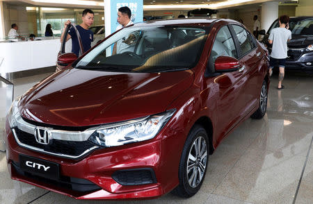 A prospective buyer talks to a salesman at a car showroom in Malaysia's southern city of Johor Bahru April 26, 2017. REUTERS/Edgar Su