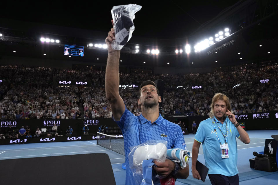 Novak Djokovic of Serbia throws gifts to the crowd following his fourth round win over Alex de Minaur of Australia at the Australian Open tennis championship in Melbourne, Australia, Monday, Jan. 23, 2023. (AP Photo/Ng Han Guan)