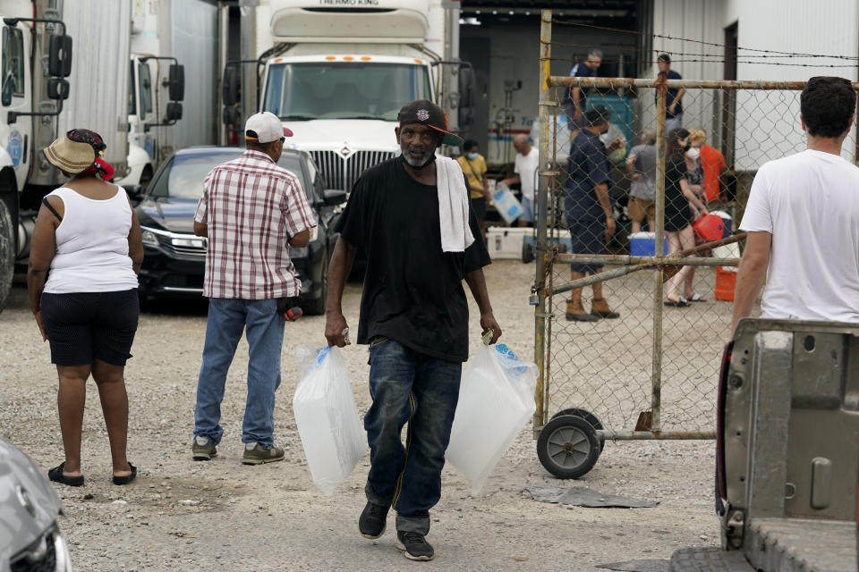 In the aftermath of Hurricane Ida, residence pick up food and ice at a distribution center Wednesday, Sept. 1, 2021, in New Orleans, La. (AP Photo/Eric Gay)