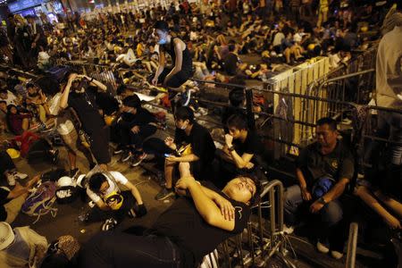 A pro-democracy protester sleeps over a barricade at the Mongkok shopping district of Hong Kong October 20, 2014. REUTERS/Carlos Barria