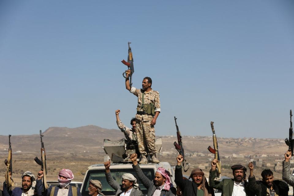 Houthi fighters and tribal supporters hold up their firearms during a protest against recent US-led strikes on Houthi targets (REUTERS)