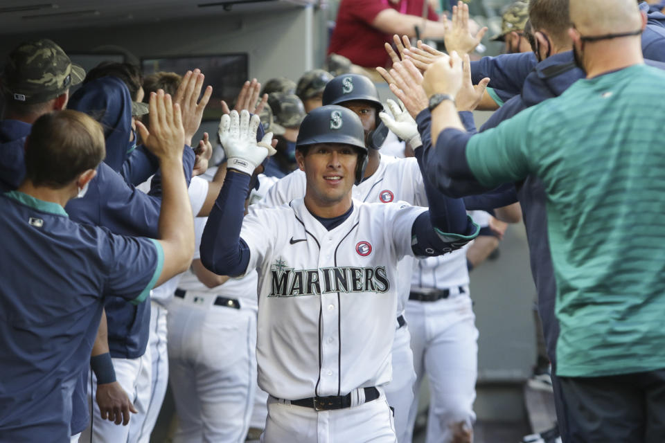 Seattle Mariners' Dylan Moore celebrates in the dugout after his three-run home run during the fourth inning of the team's baseball game against the Cleveland Indians, Saturday, May 15, 2021, in Seattle. (AP Photo/Jason Redmond)