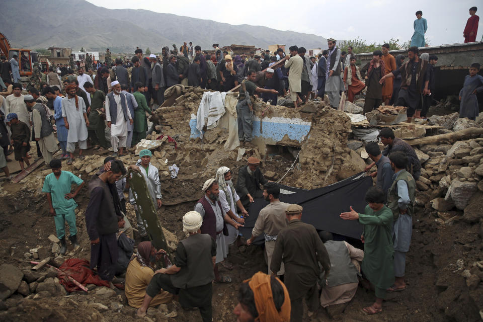 People search for victims of a mudslide following heavy flooding in Parwan province, north of Kabul, Afghanistan, Wednesday, Aug. 26, 2020. Flooding in northern Afghanistan killed and injured dozens of people officials said Wednesday. (AP Photo/Rahmat Gul)