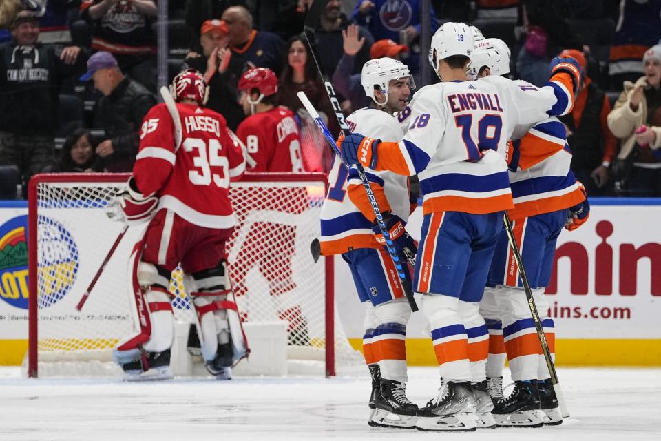 The New York Islanders celebrate after a goal by teammate Noah Dobson as Detroit Red Wings goaltender Ville Husso (35) looks away during the third period of an NHL hockey game Monday, Oct. 30, 2023, in Elmont, N.Y. (AP Photo/Frank Franklin II)