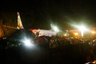 First responders gather around the wreckage of an Air India Express jet, which was carrying more than 190 passengers and crew from Dubai, after it crashed by overshooting the runway at Calicut International Airport in Karipur, Kerala, on August 7, 2020. - At least 14 people died and 15 others were critically injured when a passenger jet skidded off the runway after landing in heavy rain in India, police said on August 7. (Photo by Favas JALLA / AFP) (Photo by FAVAS JALLA/AFP via Getty Images)