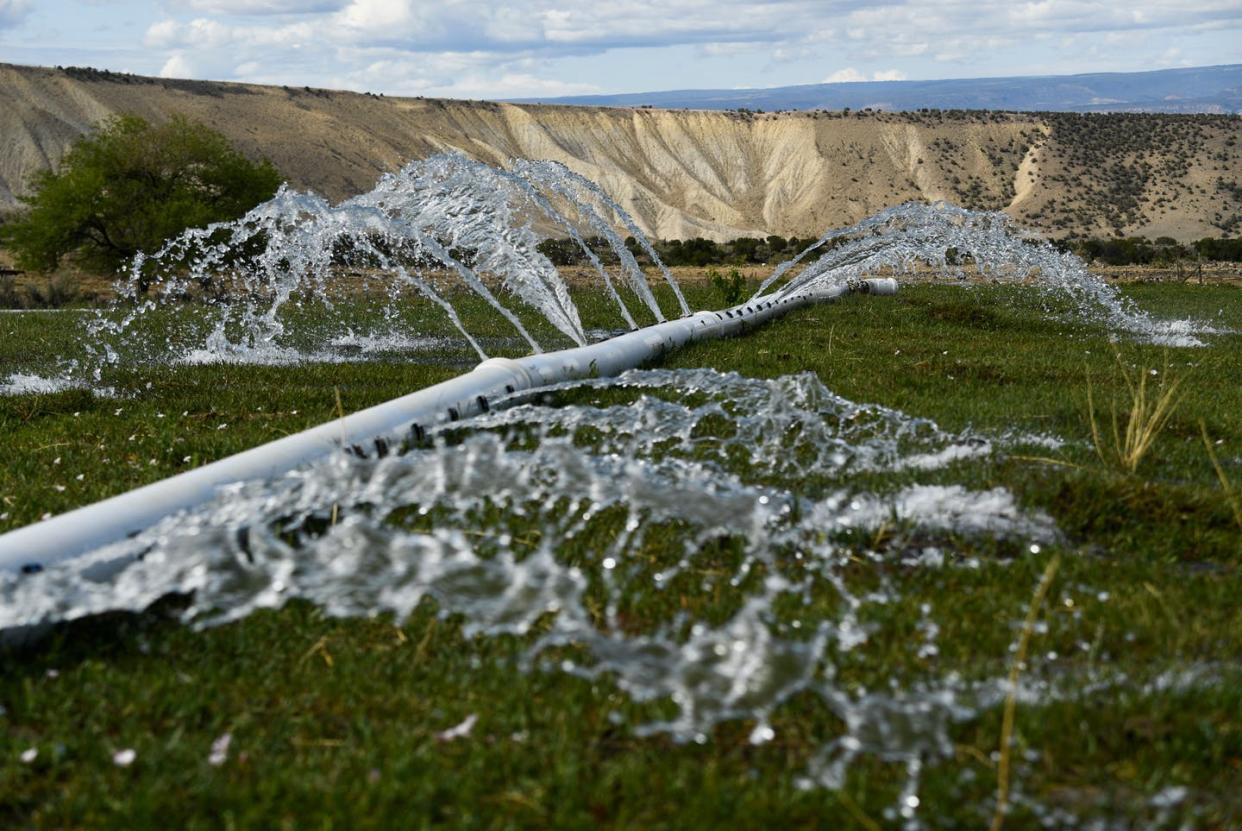 <span class="caption">Low-tech irrigation on a cattle ranch near Whitewater, Colo., June 30, 2021.</span> <span class="attribution"><a class="link " href="https://www.gettyimages.com/detail/news-photo/water-flows-from-irrigation-pipes-to-keep-parts-of-janie-news-photo/1233914594" rel="nofollow noopener" target="_blank" data-ylk="slk:Patrick T. Fallon/AFP via Getty Images;elm:context_link;itc:0;sec:content-canvas">Patrick T. Fallon/AFP via Getty Images</a></span>