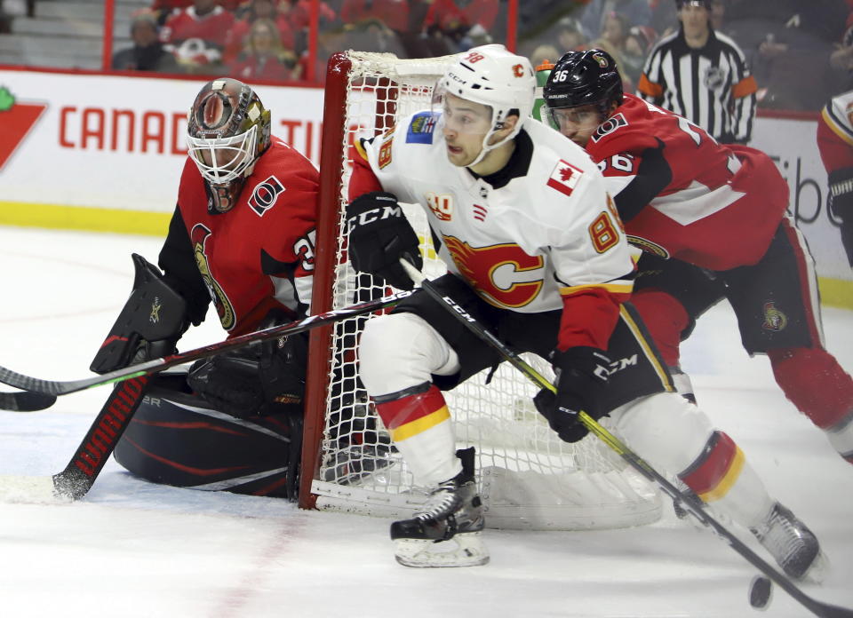 Calgary Flames left wing Andrew Mangiapane (88) attempts a wraparound as Ottawa Senators goaltender Marcus Hogberg (35) covers the near post during first-period NHL hockey game action in Ottawa, Ontario, Saturday, Jan. 18, 2020. (Fred Chartrand/The Canadian Press via AP)