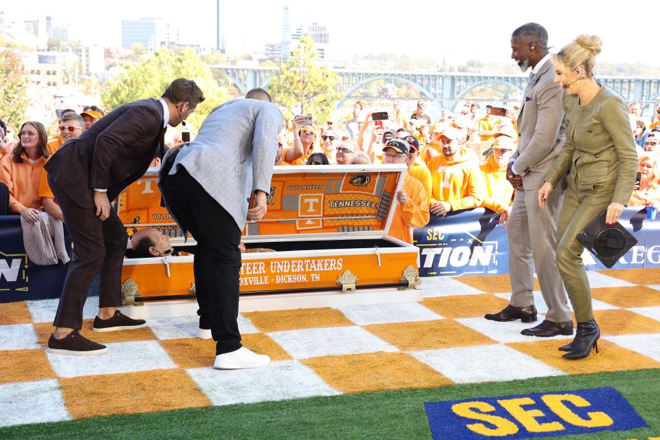 Jordan Rodgers, far left, and Tim Tebow lift the lid of a Tennessee casket to reveal Paul Finebaum during an airing of "SEC Nation" on Saturday, Oct. 15, 2022, in Knoxville.