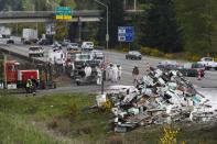 Beekeepers attend to a semi-trailer truck that overturned with a cargo of bees on a highway in Lynnwood, Washington April 17, 2015. A truck carrying millions of honey bees overturned on a freeway north of Seattle on Friday, creating a massive traffic jam as the swarming insects stung firefighters, officials said. (REUTERS/Ian Terry)