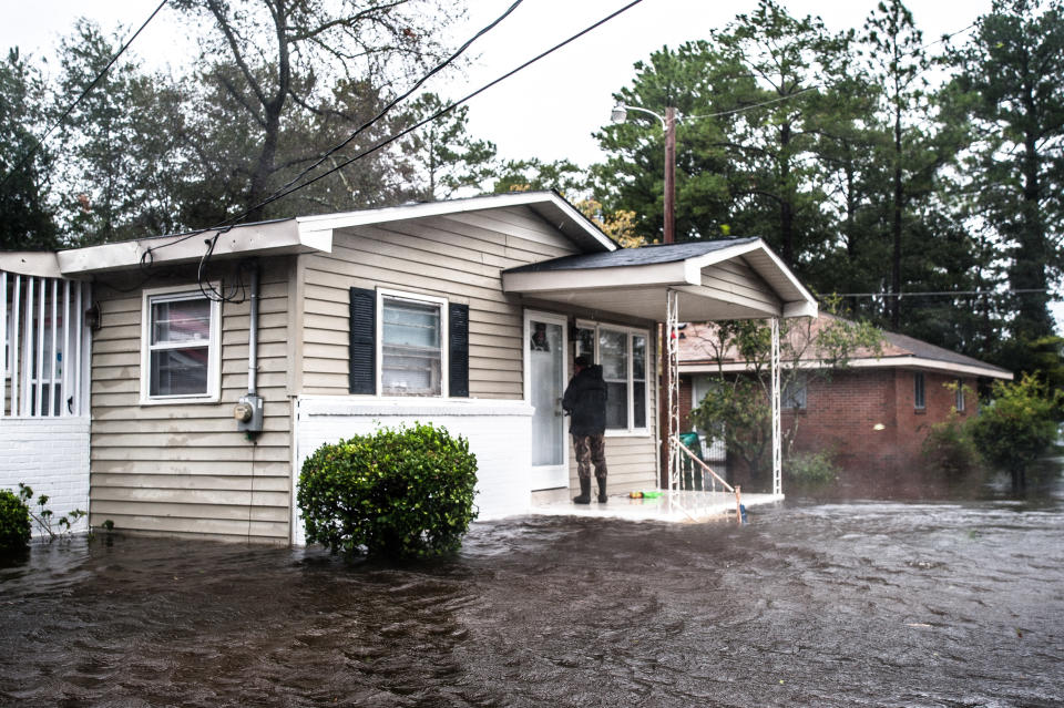 Brett Scott of Maine leaves a tag on the front door of a home in Lumberton so other rescuers will know the home has been checked and is empty.