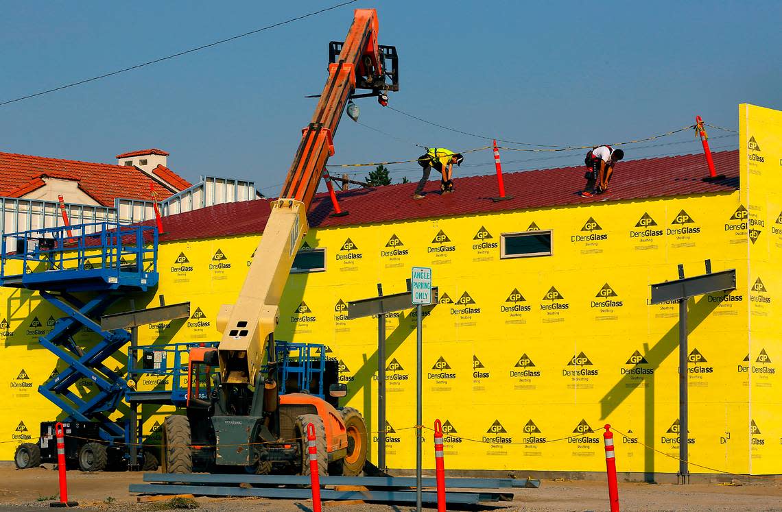 Construction workers screw down the metal roof on a 4,560-square-foot annex being built next to the Franklin County Historical Society Museum in Pasco. The annex will add space for exhibits, educational programs and archive storage. The main museum is a restored 1911 Carnegie Library and National Historic Site.