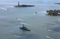 A view of the New York Harbor and a military ship participating in the Fleet Week parade of ships as seen through the window from the One World Observatory observation deck on the 100th floor of the One World Trade center tower in New York during a press tour of the site May 20, 2015. One World Observatory will open to the public on May 29. The Statue of Liberty is seen at top and Ellis Island at right. (REUTERS/Mike Segar)<br><br>