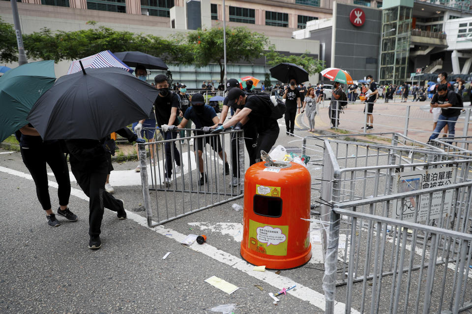 Protesters push steel barricades which they took out from roadside to block the street outside the Po Lam MTR station during the anti-extradition bill protest in Hong Kong, Sunday, Aug. 4, 2019. The first of two planned protests in Hong Kong on Sunday has kicked off from a public park just hours after police said they arrested more than 20 people for unlawful assembly and other offences during the previous night's demonstrations. (AP Photo/Vincent Thian)