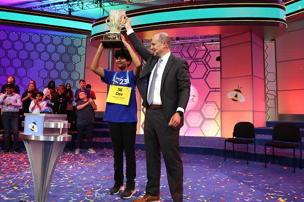 NATIONAL HARBOR, MARYLAND - JUNE 01: Speller Dev Shah of Largo, Florida, is presented with a trophy by E. W. Scripps Company CEO Adam Symson he won the 2023 Scripps National Spelling Bee at Gaylord National Hotel and Convention Center on June 1, 2023 in National Harbor, Maryland. Shah correctly spelled the word 