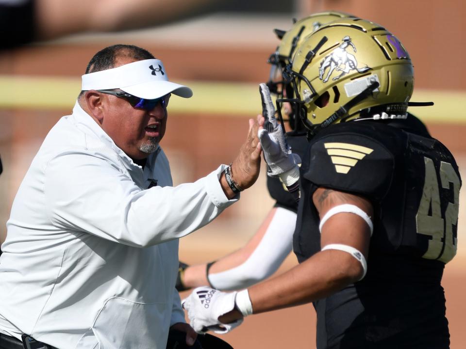 Lubbock High's head football coach Juan Rodriguez, left, high-fives Lubbock High's Zeke Rodriguez at the game against Plainview, Friday, Oct. 14, 2022, at Lowrey Field at PlainsCapital Park. 