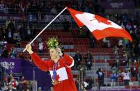 Canada's Jonathan Toews carries his country's flag after his team defeated Sweden in the men's ice hockey final game at the 2014 Sochi Winter Olympic Games, February 23, 2014. REUTERS/Brian Snyder