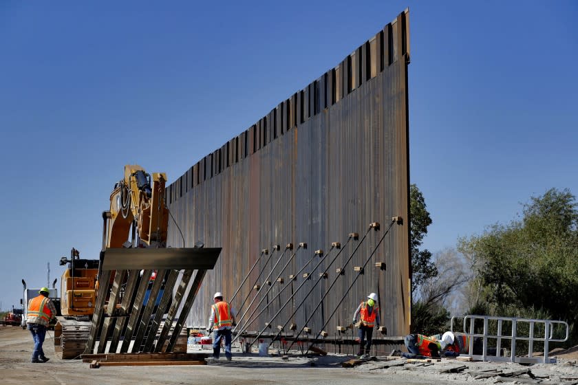 FILE - In this Sept. 10, 2019 file photo, government contractors erect a section of Pentagon-funded border wall along the Colorado River in Yuma, Ariz. The White House says construction of the U.S.-Mexico border wall will move forward after a federal appeals court ruling that frees up construction money. The 2-1 ruling on Wednesday halted a federal judge's ruling in December that had prevented the government from spending $3.6 billion diverted from 127 military construction projects to pay for 175 miles of border wall. (AP Photo/Matt York)