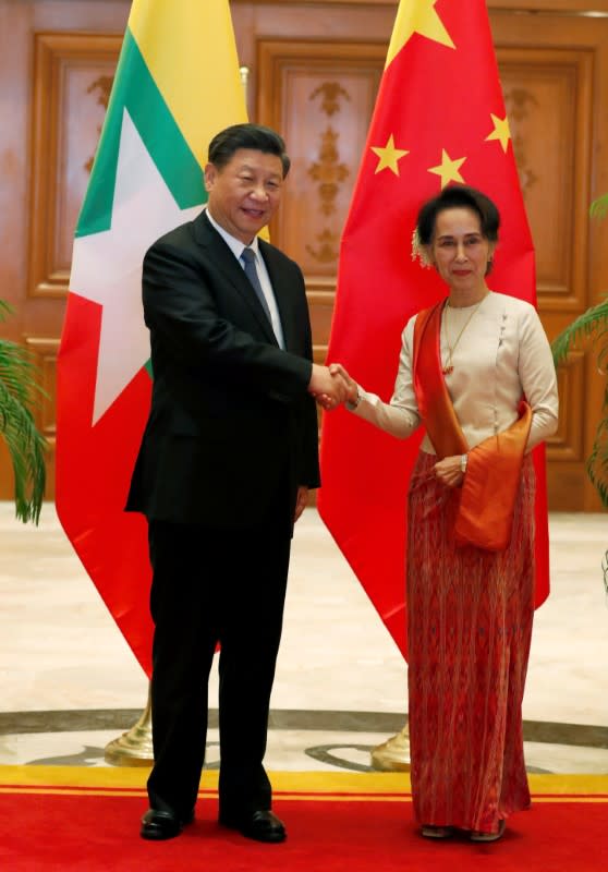 Myanmar State Counselor Aung San Suu Kyi shakes hands with Chinese President Xi Jinping at the Presidential Palace in Naypyitaw