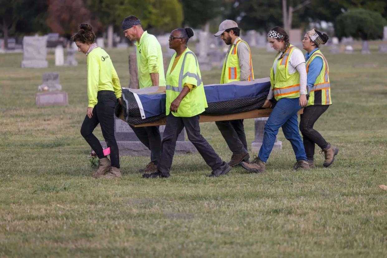Researchers carry the remains of a body exhumed at Oaklawn Cemetery on Sept. 13. They are searching for victims of the 1921 Tulsa Race Massacre in Oklahoma.