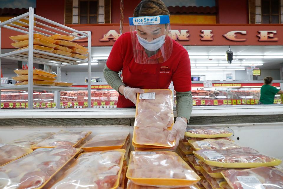 Amid concerns of the spread of COVID-19, a worker restocks chicken in the meat product section at a grocery store in Dallas, Wednesday, April 29, 2020.