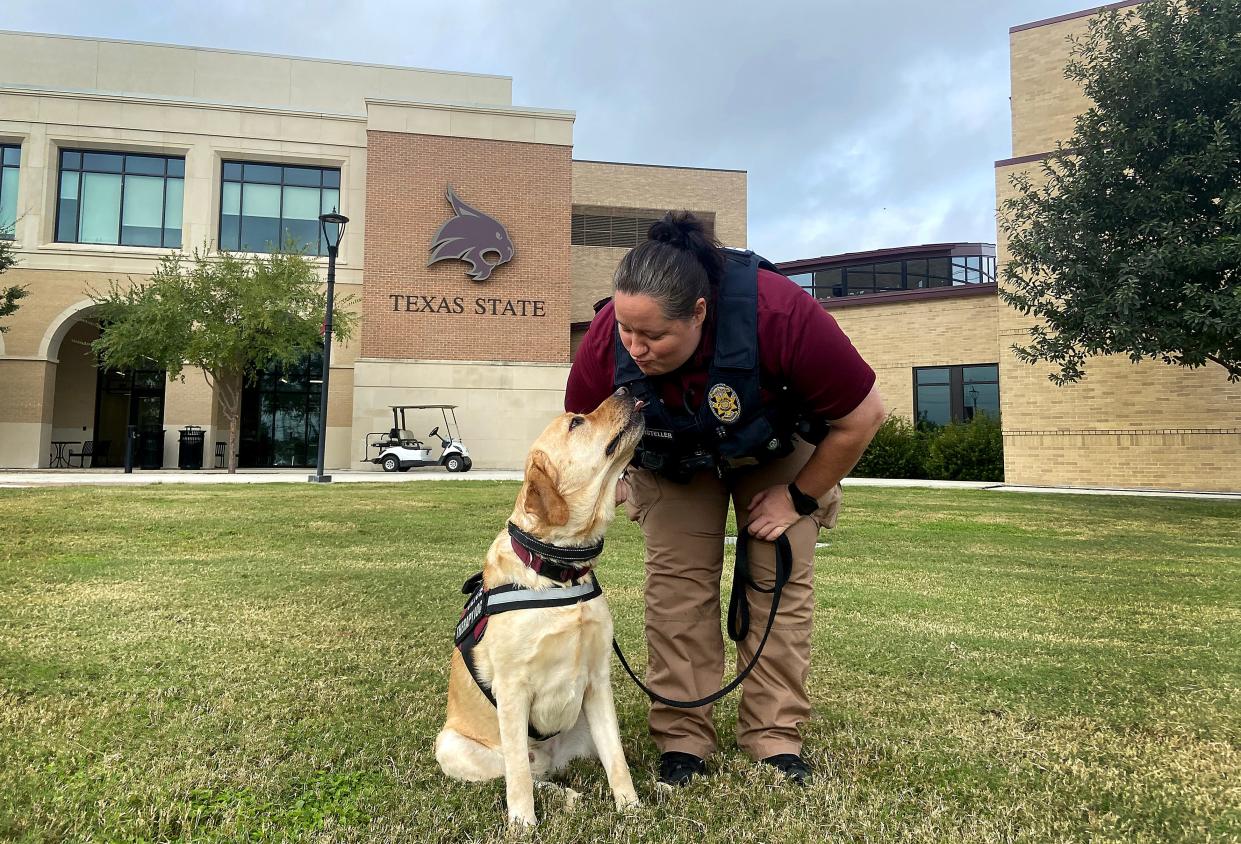 Kendra Marsteller, the mental health liaison officer at Texas State University, pets therapy dog Brady on campus in San Marcos this month.