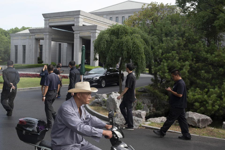 Workers pass by the Xijiao Conference Center where U.S. and Chinese trade officials gathered for talks in Shanghai Wednesday, July 31, 2019. (AP Photo/Ng Han Guan, Pool)