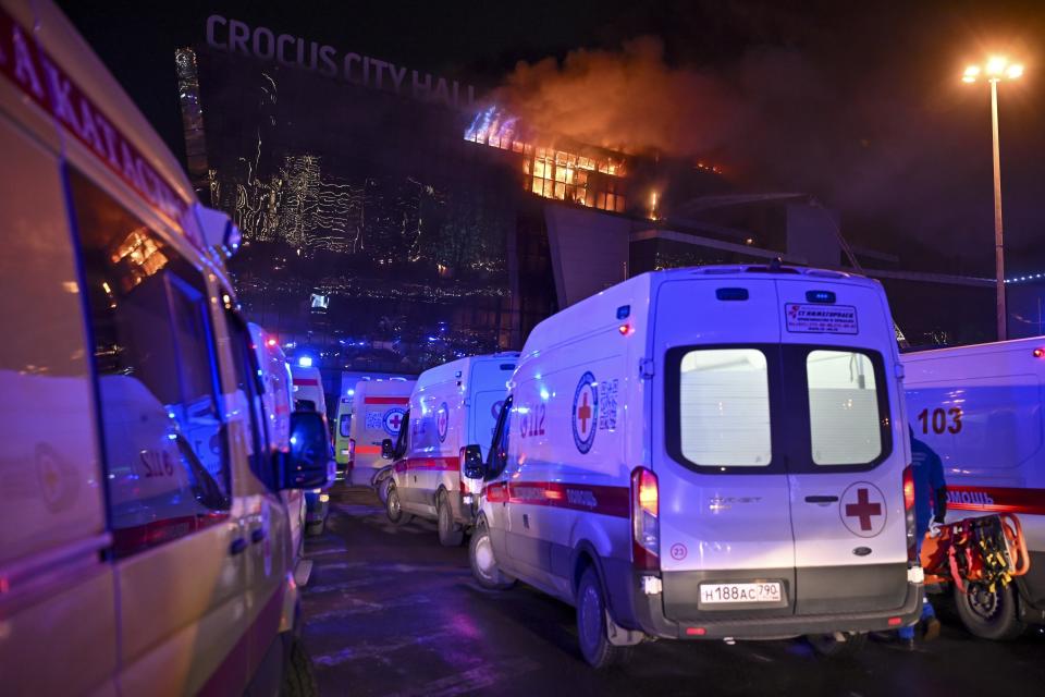 Ambulances park near a burning building of the Crocus City Hall on the western edge of Moscow, Russia, Friday, March 22, 2024. Twenty-two victims of the Russia concert hall attack that killed more than 130 people remain in serious condition in the hospital, Health Minister Mikhail Murashko said Tuesday, March 26, 2024, according to state news agency Tass. Two of them are children, it said. (AP Photo/Dmitry Serebryakov)