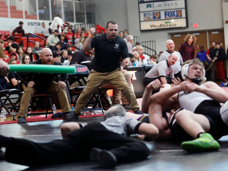 River View coach Devin Klein, middle, cheers on senior Cruz Mobley as he earns a third-period pin with six seconds left in the consolation finals at 215 pounds during the Division II district tournament on Saturday at Steubenville High School. The win set the career pins record for Mobley, won four matches in the consolation bracket to place third and qualify for his second straight state tournament.