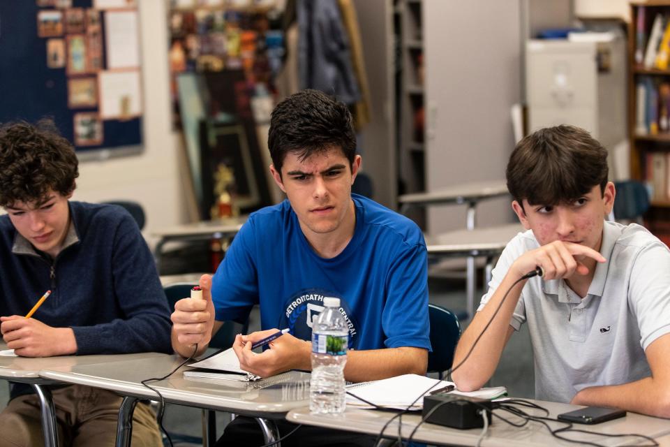 From left, Quiz Bowl team Christian Curtis, Dominic Apap and Lucas Jraiche have their fingers on the buzzer as they listen to the question being read as  during practice at Detroit Catholic Central High School in Novi on Wednesday, May 24, 2023.