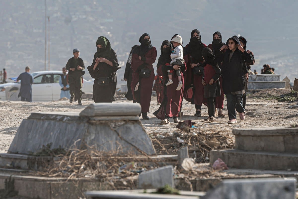 Afghan women with children walk at a graveyard at a hilltop in Kabul, Afghanistan  (AFP via Getty Images)