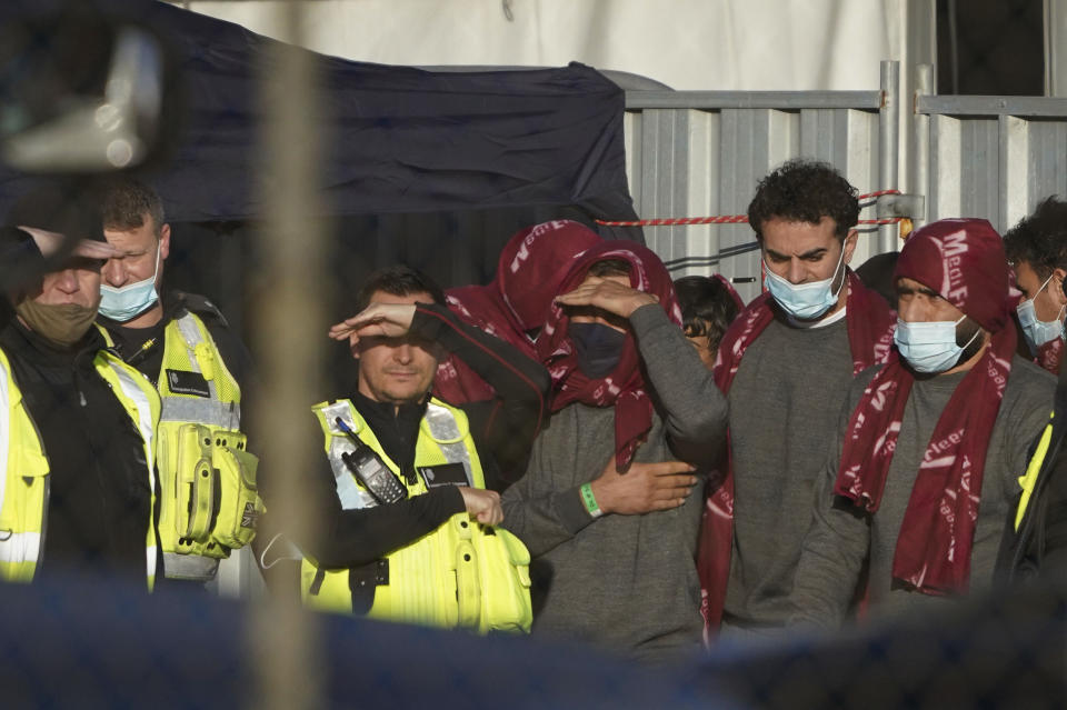 A group of people thought to be migrants wait in a holding area after being brought in to Dover, Kent, England, Thursday, Nov. 25, 2021. On Wednesday around 30 migrants bound for Britain died when their boat sank in the English Channel, in what France’s interior minister called the biggest migration tragedy on the dangerous crossing to date. (Gareth Fuller/PA via AP)