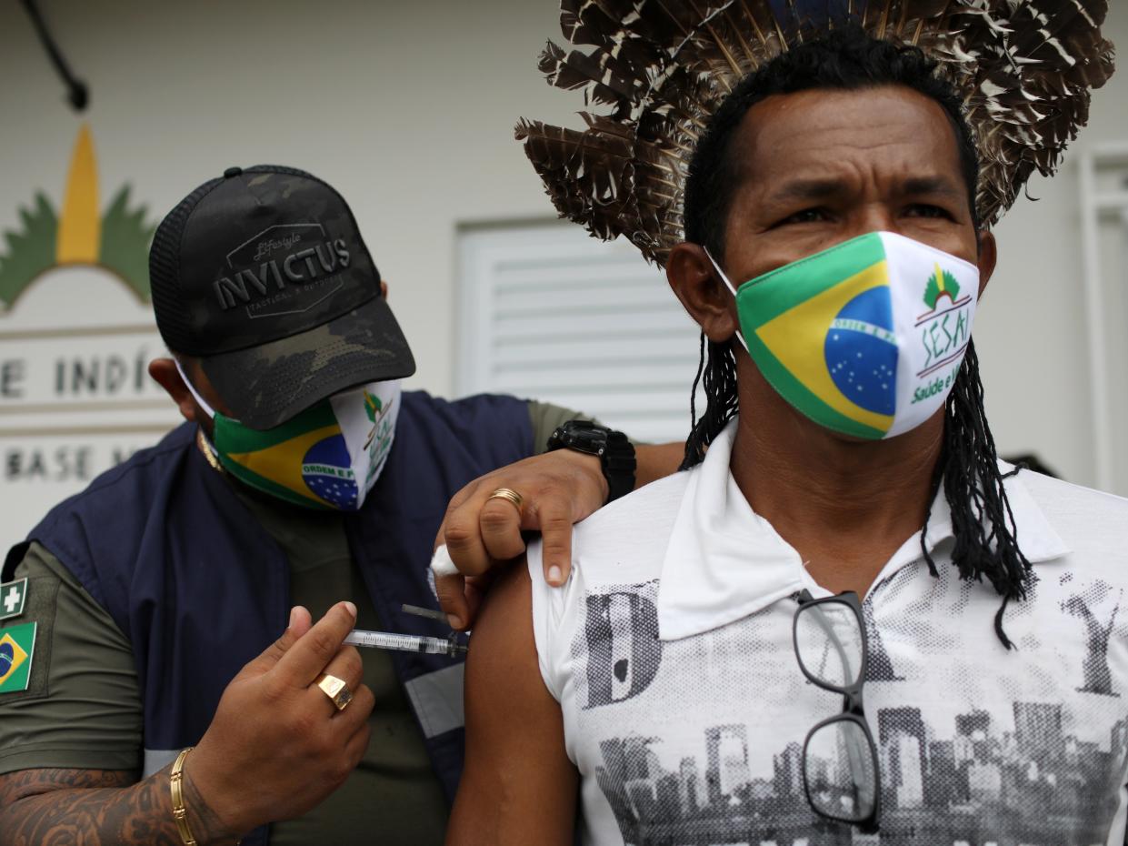 Healthcare workers have reportedly been confronted by crowds armed with bows and arrows while attempting to deliver the Covid-19 vaccine to an indigenous community in Brazil (Bruno Kelly/Reuters)