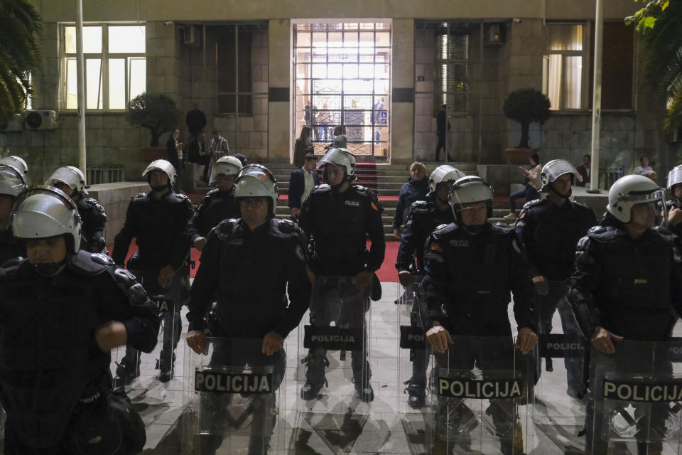 Montenegro police officers guard parliament building during a protest against new speaker of parliament Andrija Mandic in Montenegro's capital Podgorica, Monday, Oct. 30, 2023. After months of political bickering, the parliament in NATO-member and EU candidate Montenegro is set to hold a vote Monday on the small Balkan country's proposed new government that will hinge on the support from pro-Russian and anti-Western groups. Following months of negotiations, the winning coalition received the backing from staunchly anti-Western groups under the condition that one of their leaders, Andrija Mandic, is voted Monday the parliament speaker — an influential political position. (AP Photo/Risto Bozovic)