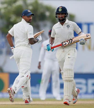 Cricket - Sri Lanka v India - First Test Match - Galle, Sri Lanka - July 26, 2017 - India's cricketers Shikhar Dhawan (L) and Cheteshwar Pujara run between wickets. REUTERS/Dinuka Liyanawatte
