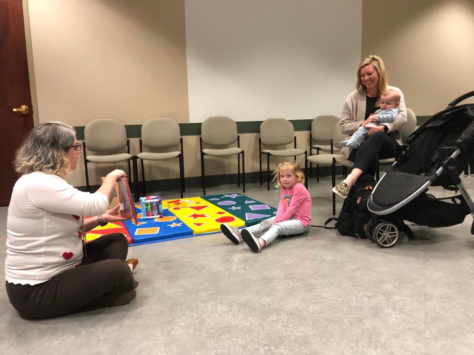 Springfield-Greene County librarian Sarah Thompson, left, reads a book about adoption to Mae Hill while her mom, Micaela, and infant brother, Hayes, look on during a story time on Tuesday, Nov. 14, at the Library Center. Micaela and Tanner Hill will finalize Hayes' adoption in February.