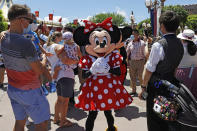 The iconic cartoon character Minnie Mouse reacts to visitors at the Hong Kong Disneyland Thursday, June 18, 2020. In March, Hong Kong closed its borders to overseas countries, restricting visitors to those who have spent more than 14 days in mainland China, Macao and Taiwan. Tourist numbers plunged nearly 90%, with only about 3.5 million visitors arriving in the city between January and June this year. The city's airlines, hospitality and tourist industries – which had already took a hit from months of anti-government protests last year – took a second beating, with the government pledging $51.6 million in subsidies to help them stay afloat. (AP Photo/Kin Cheung)