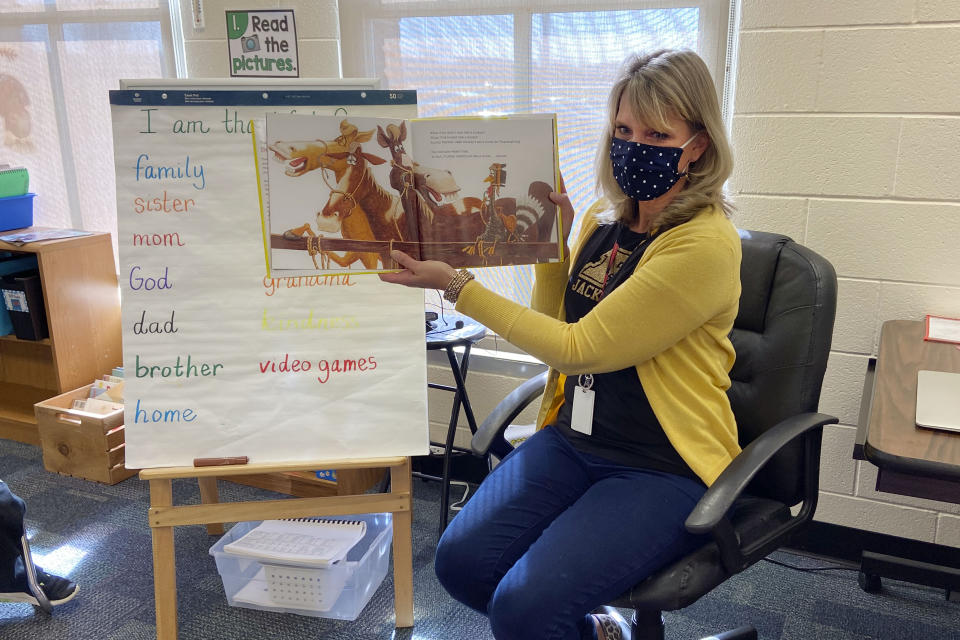 In this photo provided by Julie Mackett, the kindergarten teacher conducts her class at Ft. Meigs Elementary School, in Perrysburg, Ohio. Contact tracing and isolation protocols meant to contain the spread of the coronavirus are sidelining school employees and frustrating efforts to continue in-person learning. “I think everybody understands when you can’t have enough subs to fill the roles, it’s also a safety issue: You can’t have that many children without support from adults,” said Mackett, who went through her own two-week quarantine early in the school year after a student tested positive. (Courtesy of Julie Mackett via AP)