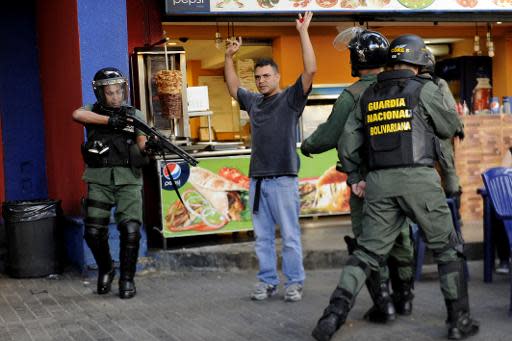 Efectivos de la Guardia Nacional Boliviariana registran a un hombre durante protestas contra el gobierno de Venezuela en Caracas el 16 de marzo de 2014 (AFP | Leo Ramirez)